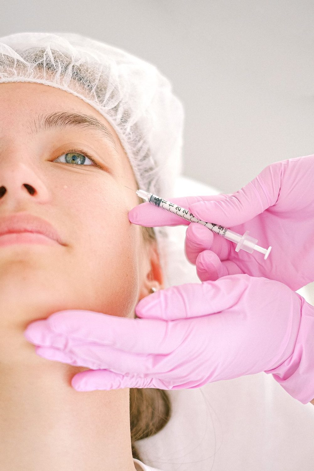 Klinik ortamda kadın hastaya ince uçlu iğneyle botoks uygulaması