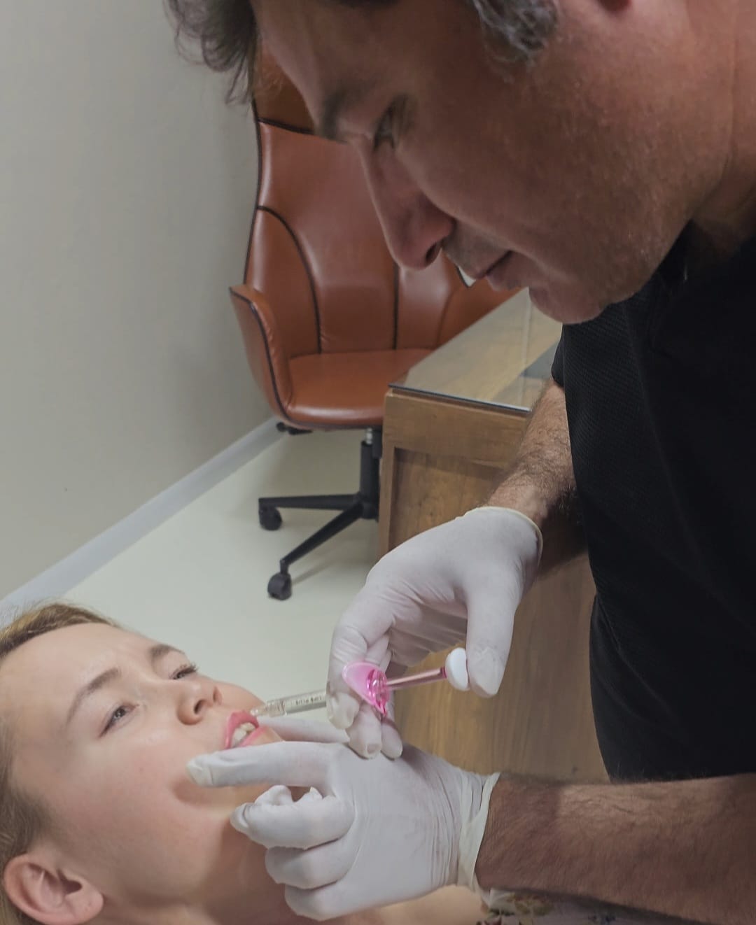 Dr. İzzet Gök, klinik ortamda bir hastaya dudak dolgusu uygularken